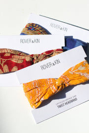 A collection of recycled sari headbands in assorted patterns and colors, with the brand Rover & Kin visible on the packaging.